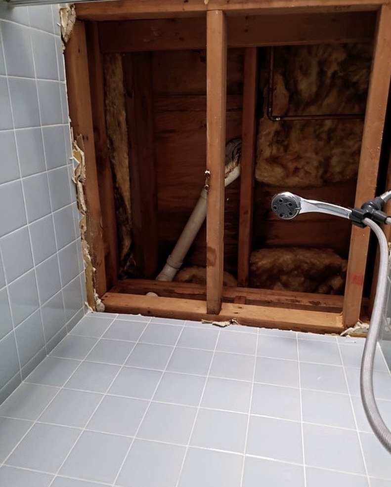 Shower wall demo — access opened for plumbing repair